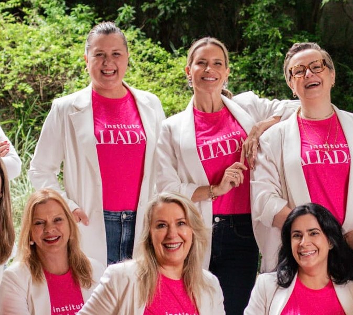 Integrantes do Instituto Aliadas reunidas em retrato coletivo de grupo, com camisetas pink e blazers brancos